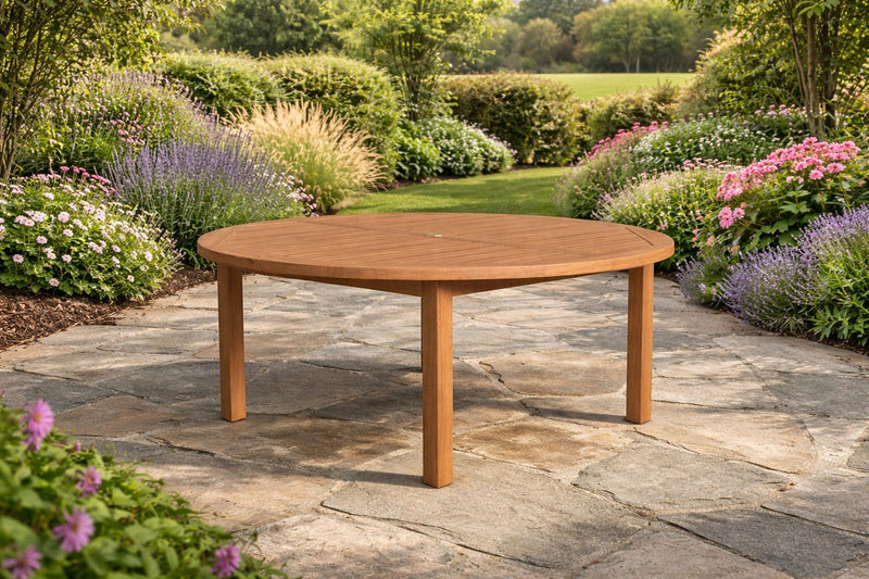 Round teak garden table on a paved terrace