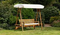 Teak Swing Seat with an ecru canopy on the lawn