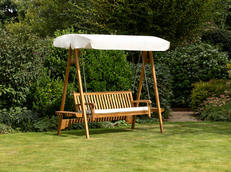 Teak Swing Seat with an ecru canopy on the lawn