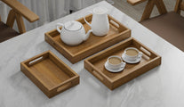A Set of 3 Rectangular Teak Trays with Slotted Handle serving tea