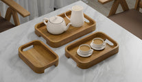 A Set of 3 Rectangular Teak Trays with Curved Corners and Integral Handle serving tea