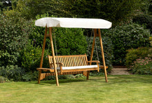 Teak Swing Seat with an ecru canopy on the lawn