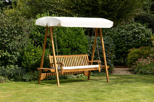 Teak Swing Seat with an ecru canopy on the lawn