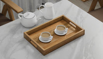 A Rectangular Teak Tray with Slotted Handle serving cups of tea